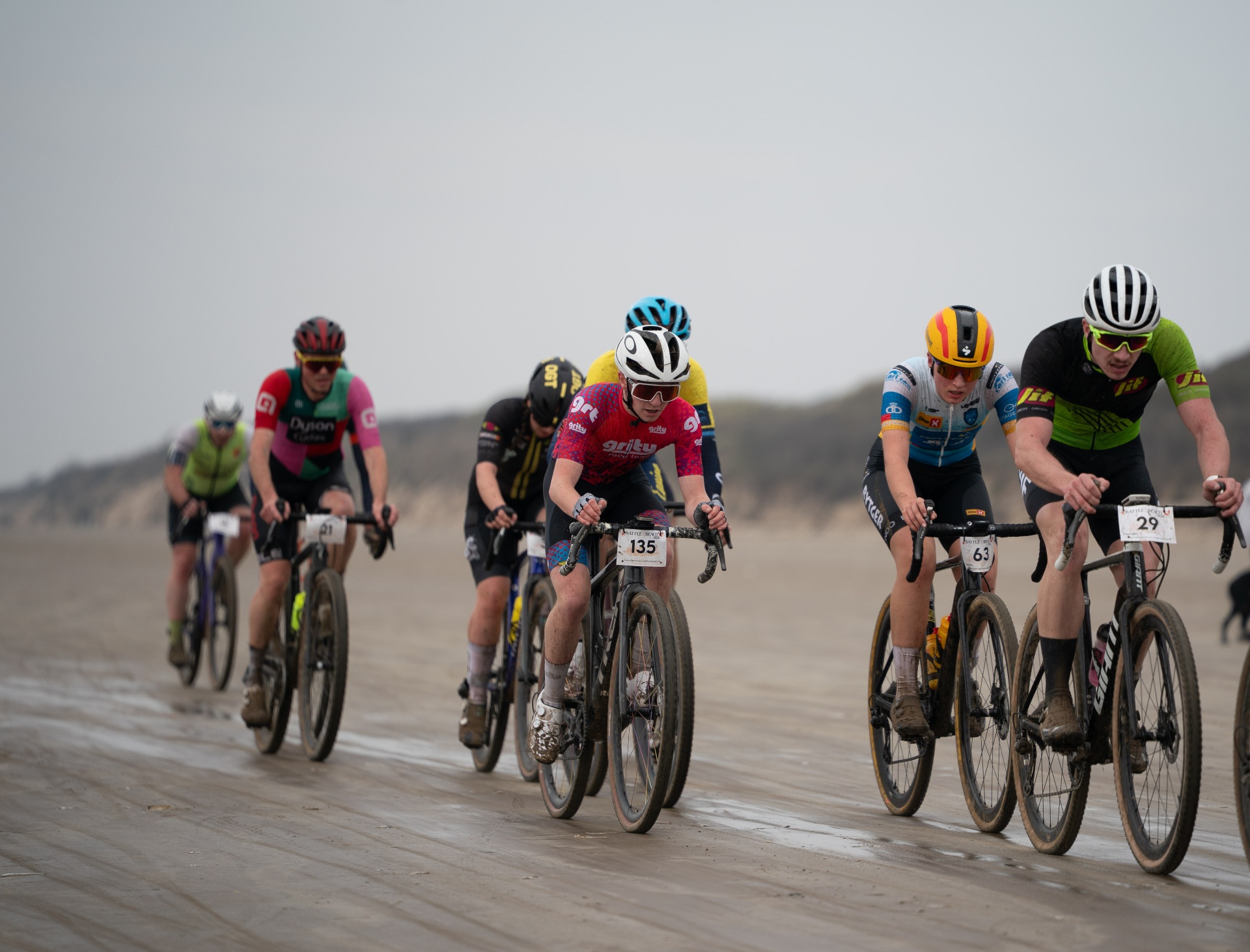 Riders racing across the sand at Battle on the Beach gravel race